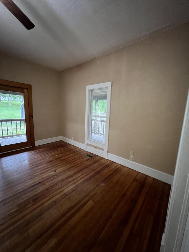 429 S Eagle Ave, Norwood, MO 65717 - empty room featuring baseboards, dark wood-style flooring, and a healthy amount of sunlight