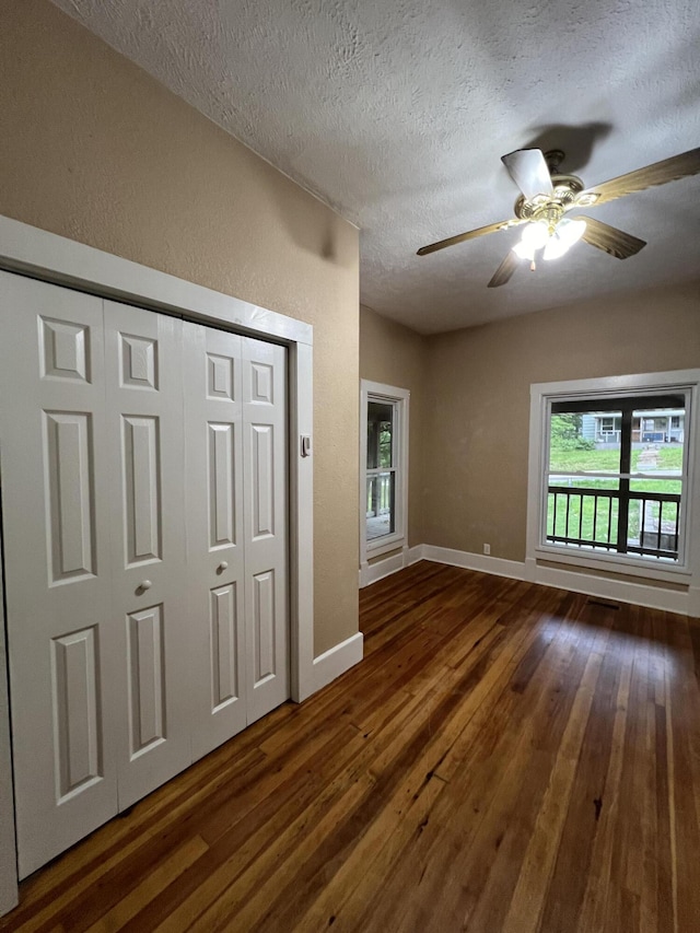 429 S Eagle Ave, Norwood, MO 65717 - unfurnished living room with a ceiling fan, a textured ceiling, a textured wall, dark wood finished floors, and baseboards