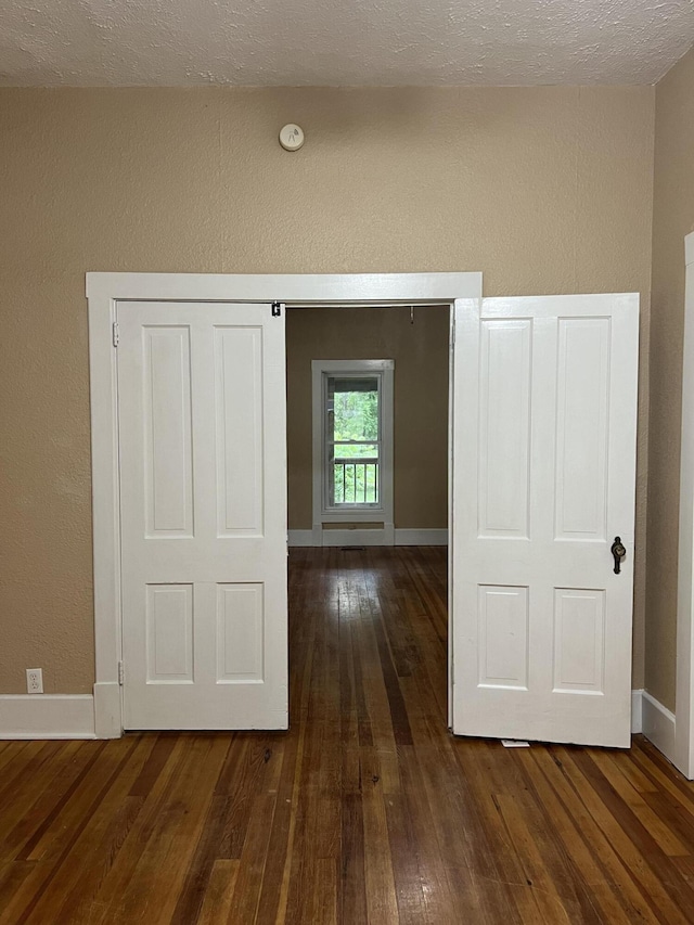 429 S Eagle Ave, Norwood, MO 65717 - corridor featuring baseboards, dark wood-style flooring, and a textured wall