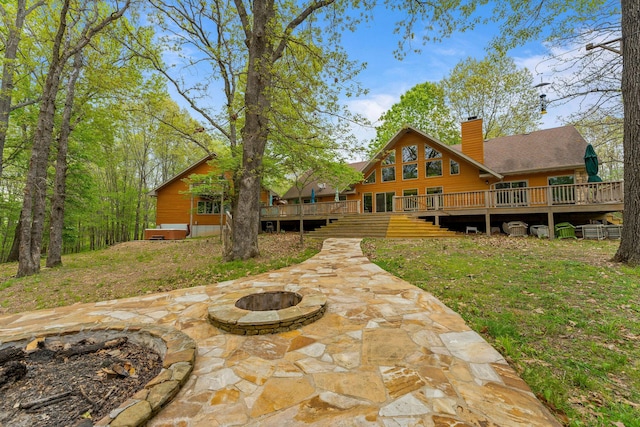 24265 Raintree Ln, Shell Knob, MO 65747 - back of property featuring a wooden deck, a patio area, a chimney, and an outdoor fire pit