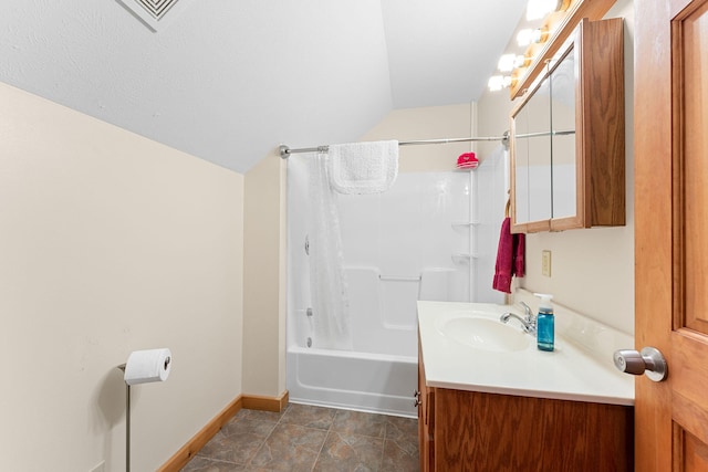 bathroom featuring shower / bath combo with shower curtain, vaulted ceiling, and vanity