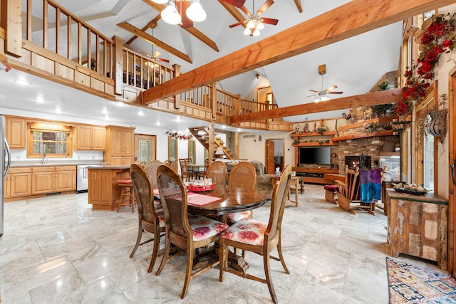 dining room with a stone fireplace, beam ceiling, high vaulted ceiling, and a wealth of natural light