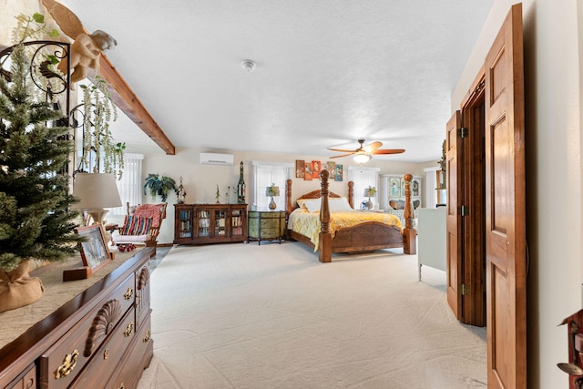 bedroom featuring light carpet, a textured ceiling, beam ceiling, and an AC wall unit