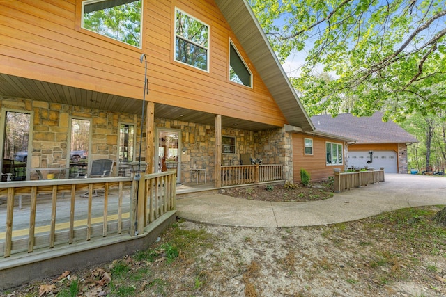 24265 Raintree Ln, Shell Knob, MO 65747 - exterior space with stone siding, an attached garage, a porch, and concrete driveway
