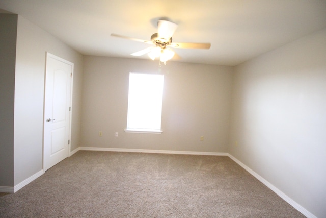 carpeted spare room featuring ceiling fan