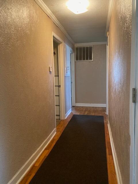 hall featuring crown molding and hardwood / wood-style floors