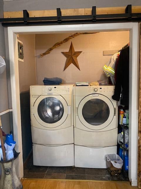 laundry area with dark tile patterned floors and washer and dryer