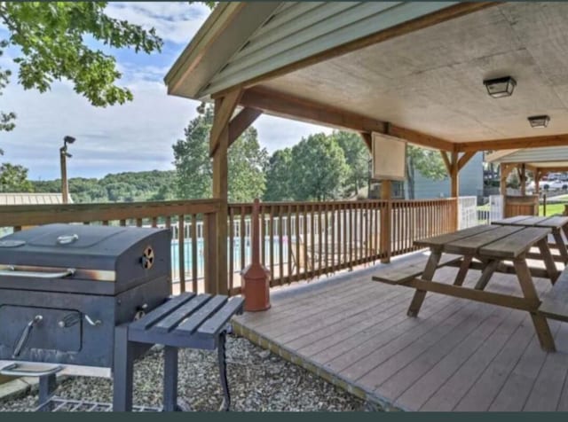 deck with grilling area and outdoor dining area