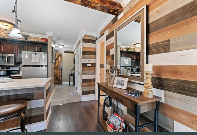 kitchen featuring crown molding, dark brown cabinetry, beam ceiling, stainless steel appliances, and dark hardwood / wood-style floors