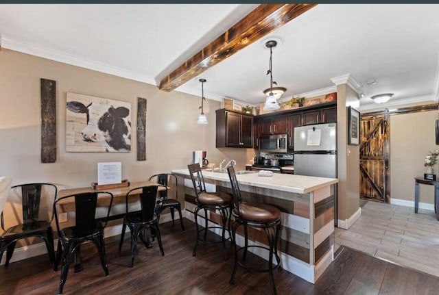 kitchen featuring stainless steel appliances, hardwood / wood-style flooring, kitchen peninsula, a barn door, and dark brown cabinets