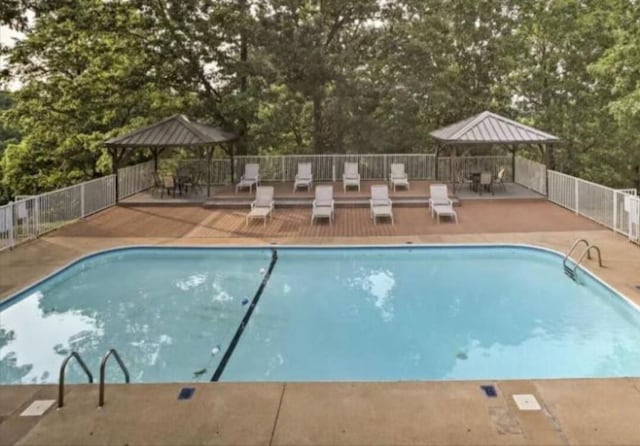 pool featuring a gazebo and fence