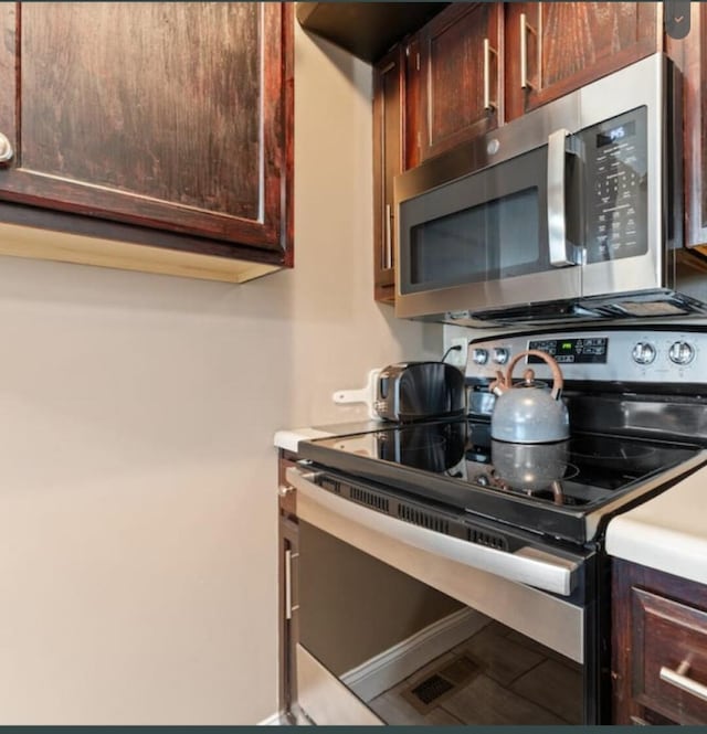 kitchen featuring dark brown cabinetry, stainless steel appliances, and light countertops