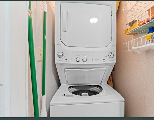 laundry area with stacked washer and dryer and laundry area