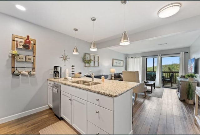 kitchen with light stone counters, white cabinets, hardwood / wood-style flooring, and stainless steel dishwasher