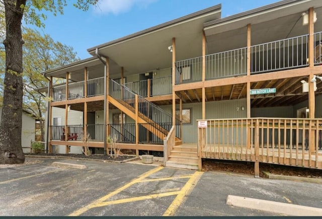 view of property featuring uncovered parking and stairway