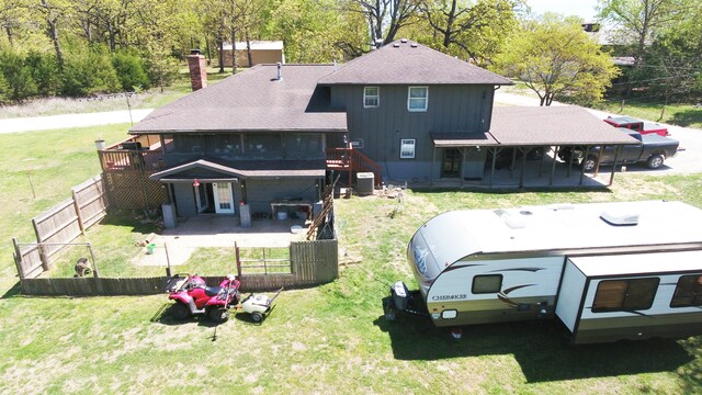 rear view of house with a wooden deck, cooling unit, a patio, and a lawn