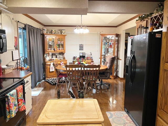 dining room with a notable chandelier, ornamental molding, and dark hardwood / wood-style floors