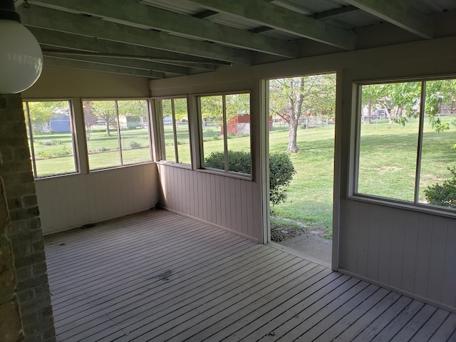 unfurnished sunroom with beam ceiling