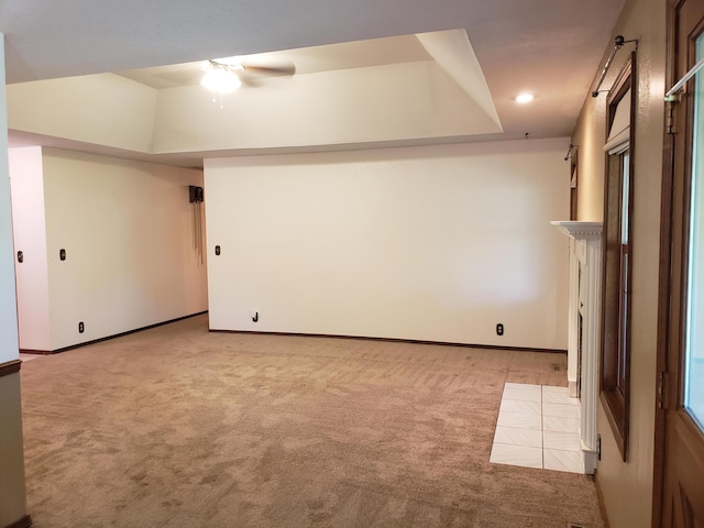 carpeted empty room featuring a tray ceiling and ceiling fan