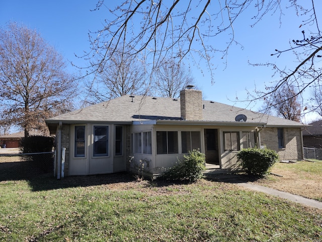 back of property with a yard and a sunroom