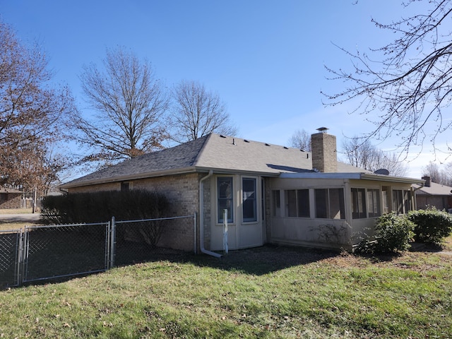 back of house featuring a yard and a sunroom