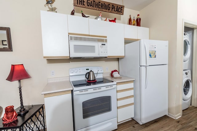 813 Holiday Rdg Unit 6, Branson, MO 65616 - kitchen with light countertops, wood finished floors, white appliances, stacked washing maching and dryer, and white cabinetry