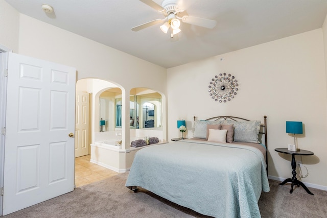 813 Holiday Rdg Unit 6, Branson, MO 65616 - bedroom featuring a ceiling fan, ensuite bathroom, arched walkways, carpet floors, and baseboards