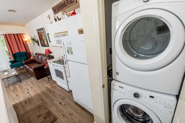 813 Holiday Rdg Unit 6, Branson, MO 65616 - clothes washing area featuring visible vents, wood finished floors, stacked washer and clothes dryer, and laundry area