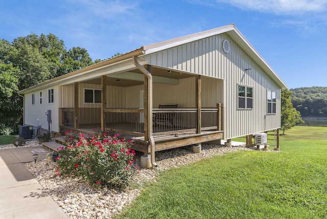 rear view of house with a yard and central air condition unit