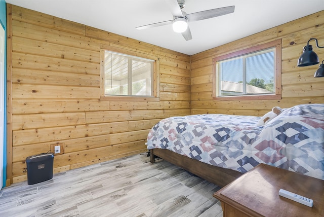 bedroom with hardwood / wood-style flooring, ceiling fan, and wood walls