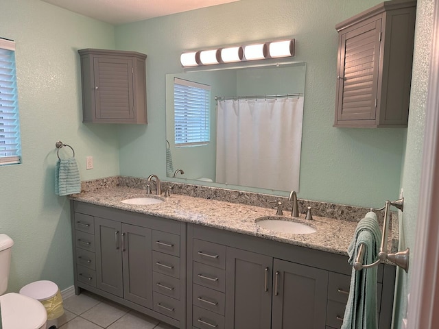 bathroom with curtained shower, vanity, toilet, and tile patterned floors