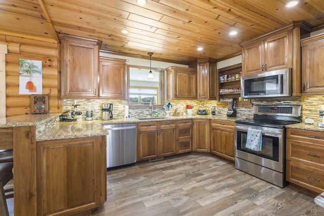 kitchen with hardwood / wood-style floors, kitchen peninsula, a breakfast bar area, appliances with stainless steel finishes, and decorative light fixtures