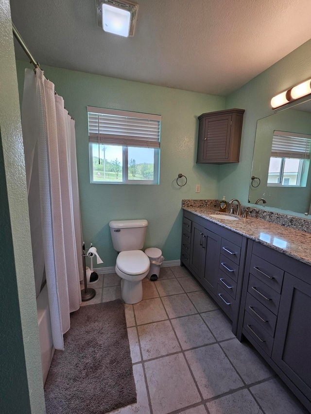 full bathroom featuring a healthy amount of sunlight, toilet, vanity, and a textured ceiling