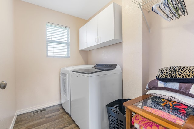 washroom with washer and clothes dryer, dark hardwood / wood-style floors, and cabinets