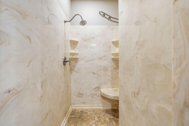 full bathroom with baseboards and a marble finish shower