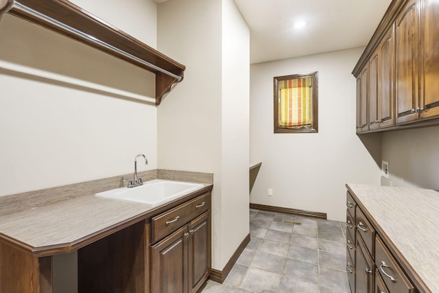 washroom with hookup for a washing machine, baseboards, cabinet space, and a sink