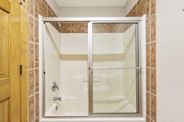 bathroom with combined bath / shower with glass door