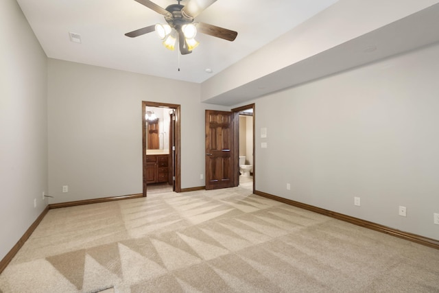 unfurnished bedroom with ceiling fan, connected bathroom, and light colored carpet