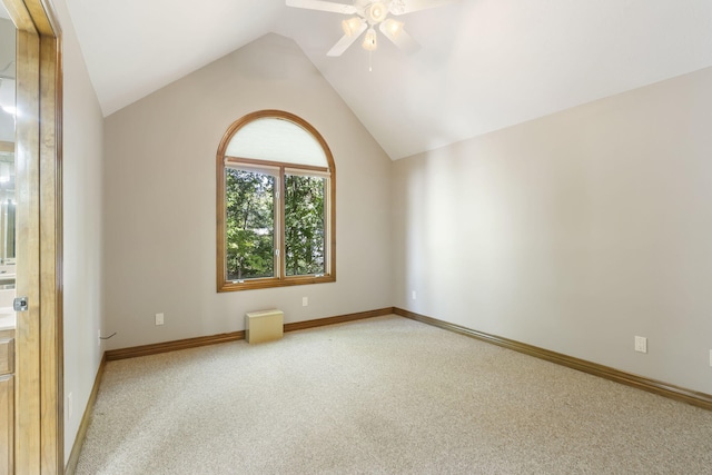empty room with ceiling fan, light carpet, lofted ceiling, and baseboards