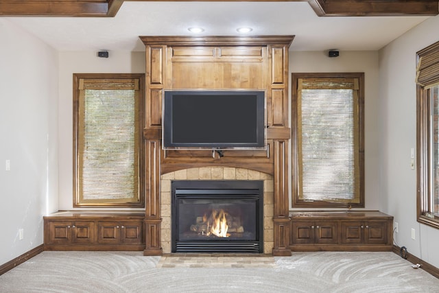 unfurnished living room featuring light colored carpet, plenty of natural light, and a tile fireplace