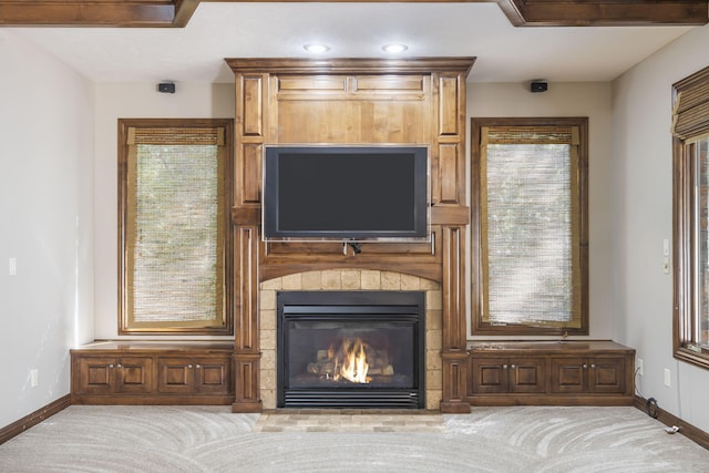 interior details featuring a glass covered fireplace, baseboards, recessed lighting, and carpet
