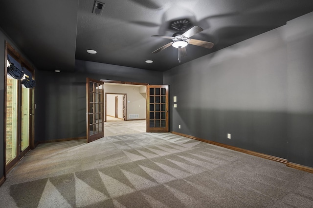 unfurnished room featuring carpet, visible vents, ceiling fan, and french doors