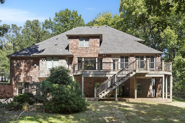 back of property featuring brick siding, a shingled roof, a wooden deck, and stairs