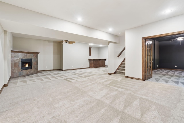 basement featuring a stone fireplace and light carpet