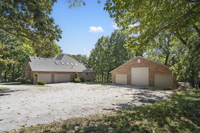 view of front facade featuring a garage, brick siding, and an outdoor structure