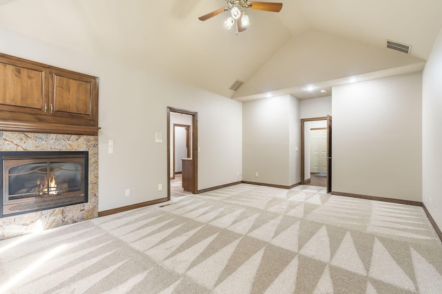 unfurnished living room with ceiling fan, light colored carpet, high vaulted ceiling, and a tile fireplace