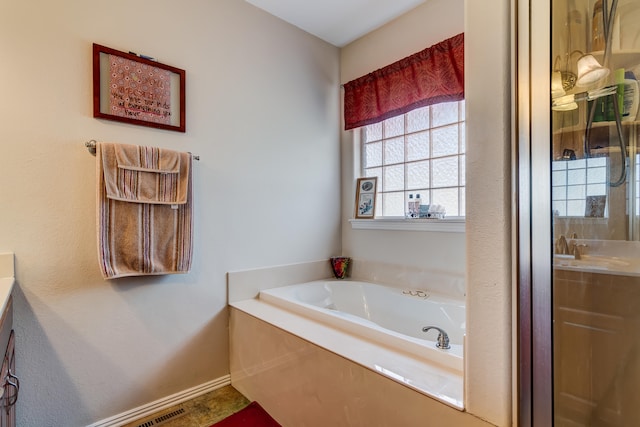 bathroom with vanity and a tub to relax in