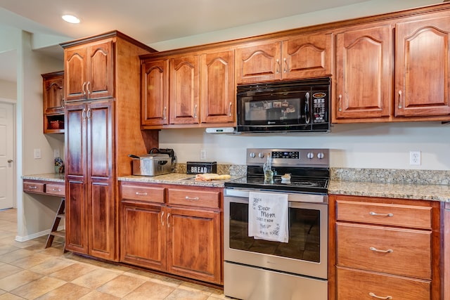 kitchen with light tile patterned flooring, light stone countertops, and electric range