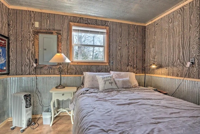 bedroom with electric panel and hardwood / wood-style floors