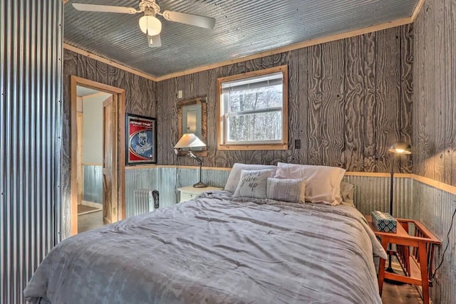 bedroom featuring ceiling fan and wood walls